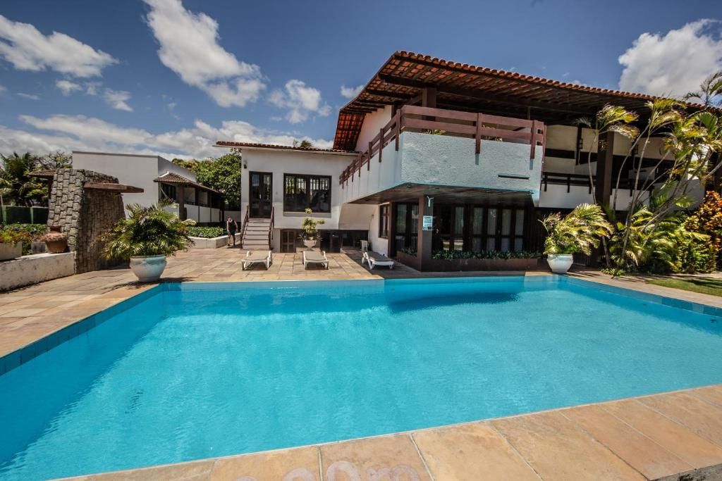 Una casa moderna con piscina, un muro de piedra y un área de patio.