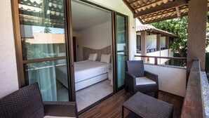 A balcony with a bed, wicker furniture, and a view of the outside. - Duro Beach Garden Hotel (Caucaia)
