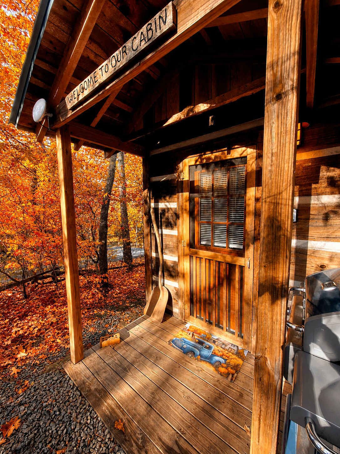 L’entrée d’un chalet en bois, avec une pancarte indiquant : « BIENVENUE DANS NOTRE CHALET ».