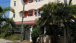 A multi-story building with a red roof, white walls, and balconies. - The Impala Mauritius Holiday Rentals (Mont Choisy)
