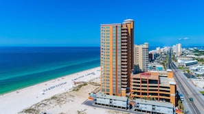 Ein Hochhotel mit mehreren Etagen, einer Strandlage und einer Tiefgarage.