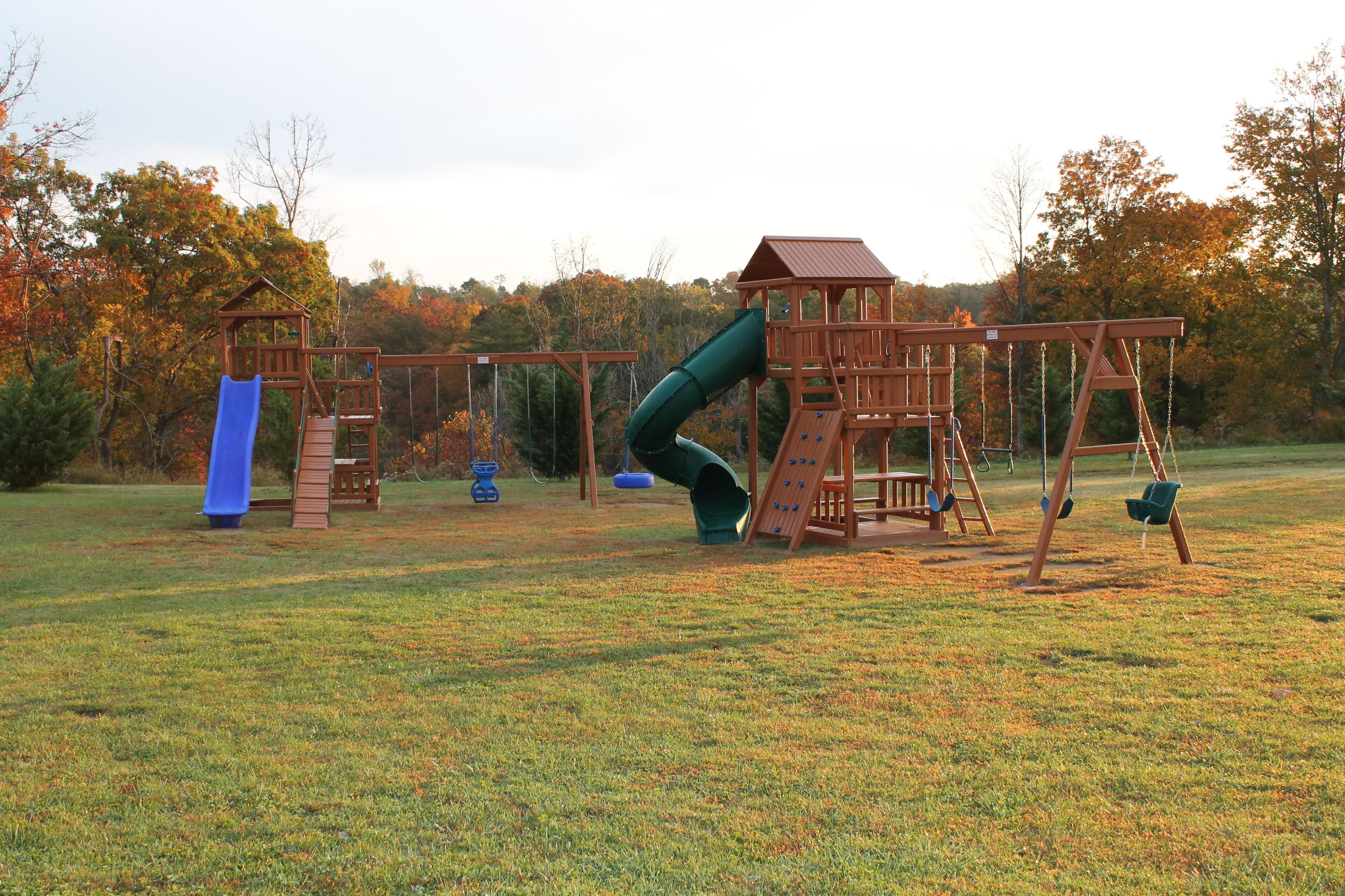 Ein Spielplatz mit Rutsche, Schaukeln und einer Kletterkonstruktion.
