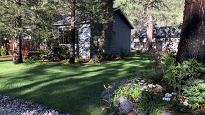 A well-maintained garden with a wooden deck, a shed, and a lawn. - Charming, Cozy, Cottage. Location Perfect for Outdoor enthusiasts and Couples (South Lake Tahoe)