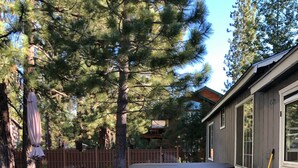 A backyard with a patio, a hot tub, and a wooden deck. - Charming, Cozy, Cottage. Location Perfect for Outdoor enthusiasts and Couples (South Lake Tahoe)