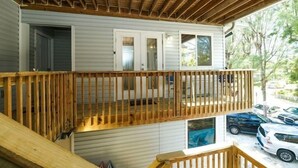 A two-story house with a wooden deck and a covered porch. - 3902 Gulf Dr 1 1 Bedroom Apts by RedAwning (Holmes Beach)