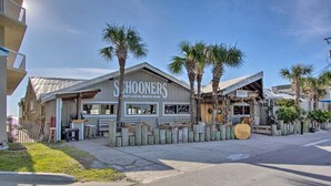 A beachfront building with a sign reading "Shooners East Local Beach Club." - 😎 Sun, Fun, Beach and Sand😎  FREE Beach Chairs!!  3 payments available Book now  (Panama City)