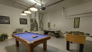 A recreational room with a pool table, foosball table, and billiards table. - 1048 TUSC (Davenport)