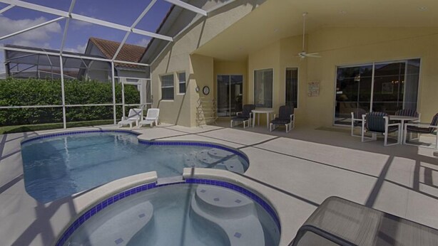 A pool area with a hot tub, lounge chairs, and a covered patio. - 1048 TUSC (Davenport)