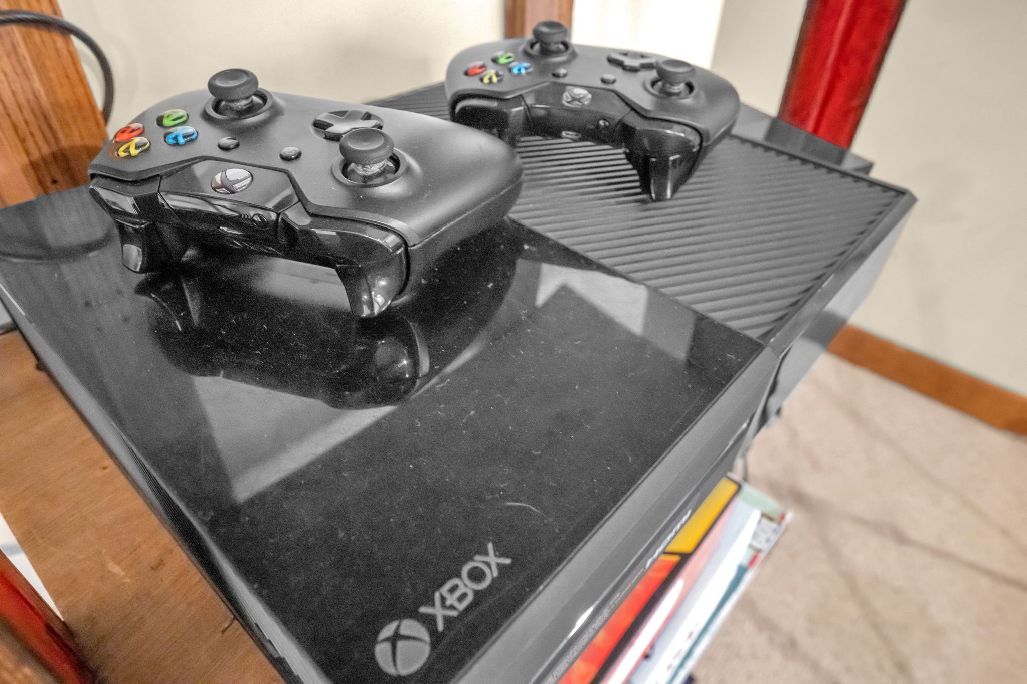 Une console Xbox noire avec deux manettes posées dessus.