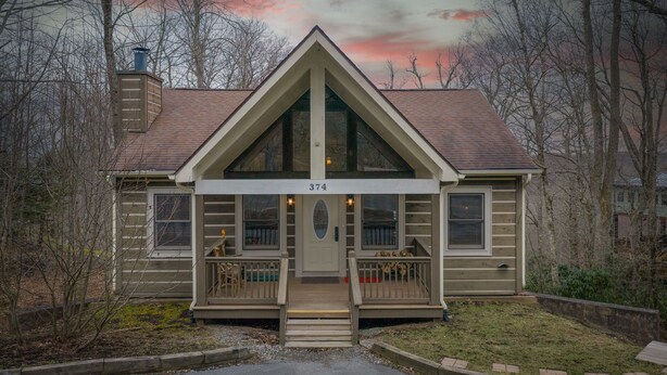A two-story house with a gabled roof, a front porch with a staircase, and a number "374" displayed above the door. - 2 Master Suite Cabin! Walk to Appalachian Ski Mtn. Hot Tub, Game Room & Fire Pit (Blowing Rock)