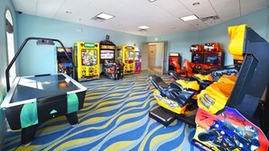 Habitació amb taula de billar, jocs recreatius i simulador de carreres.
