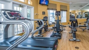 A gym with treadmills, elliptical machines, and weight equipment. - Tinkerbell's Retreat 7 Bed Emerald Island Villa (Kissimmee)