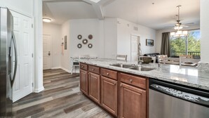 A spacious kitchen with a large island, wooden cabinets, and a stainless steel dishwasher. - *BRAND NEW! * CHARMING ORLANDO VISTA CAY  3/BR  2/ FULL BATH CONDO  *SLEEPS 6-8* (Orlando)