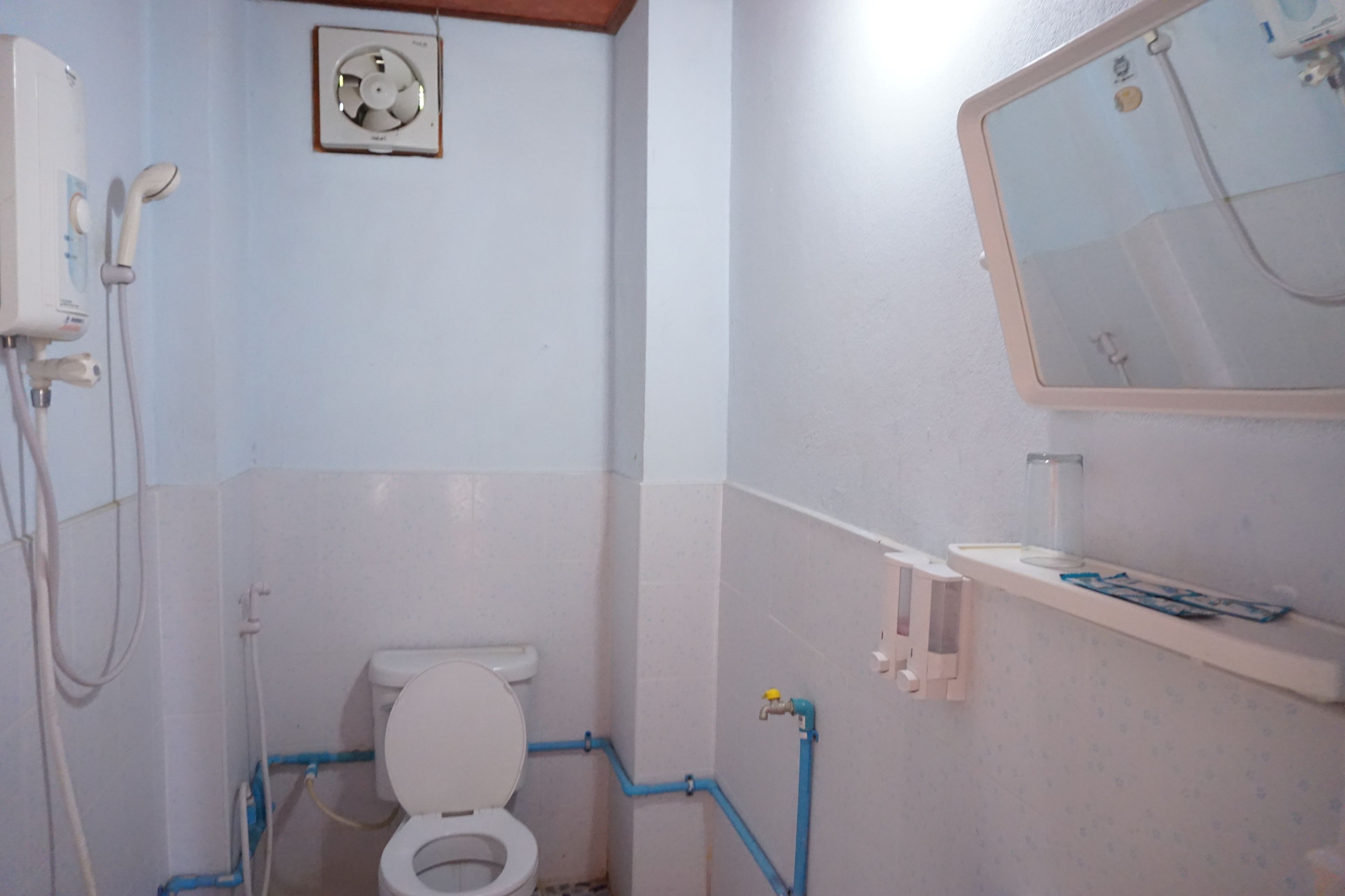 A bathroom with a toilet, a shower, and a sink.