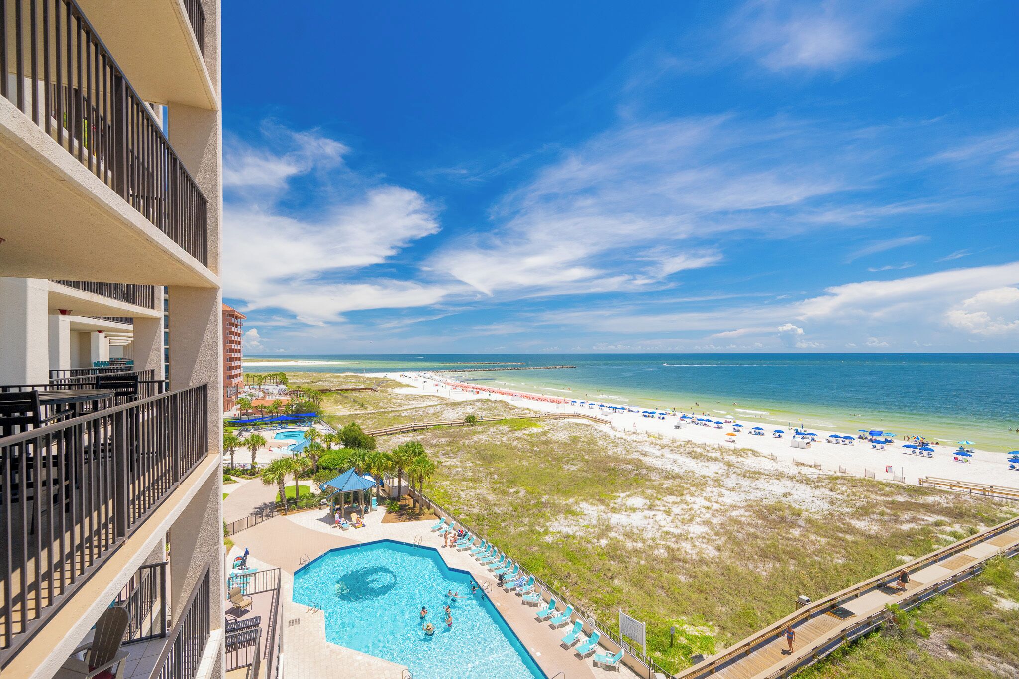 A resort with a swimming pool, beach, and ocean view.