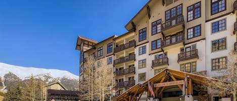 A multi-story hotel with balconies and a covered entrance.