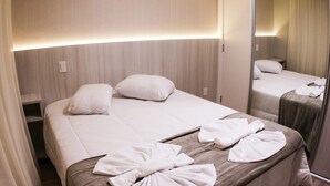 A hotel room with a bed, pillows, and a mirror reflecting the bed. - Gramado me Aptos de Luxo Via Florida (Gramado)