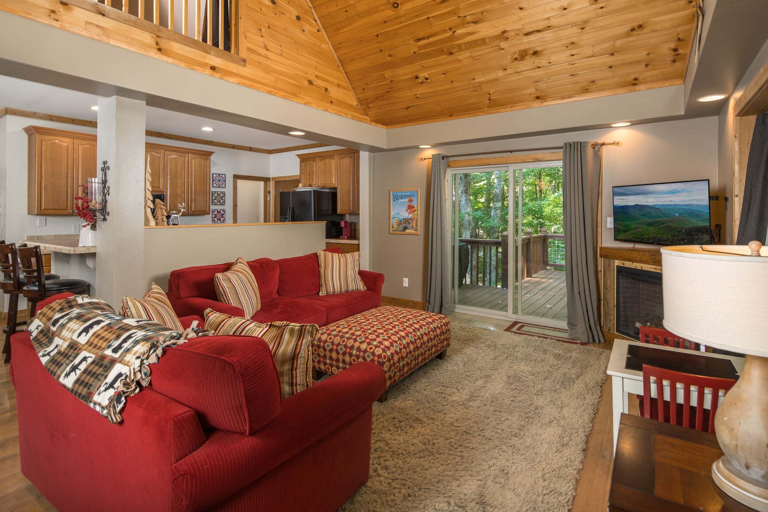 A cozy living room with a red sofa, a fireplace, and a television.