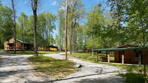 A campground with wooden cabins, a covered picnic area, and a gravel path. - The 87Getaway Cabin #1 (Mountain View)