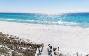 Une plage avec une promenade en bois qui mène au bord de l’eau.