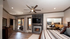 A spacious bedroom with a large bed, a fireplace, a ceiling fan, and a TV mounted on the wall. - Remodeled Penthouse - Ski In/Out - Huge Decks/Views - Private Hot Tub/Sauna (Durango)