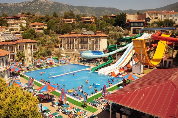 A resort with a swimming pool, water slides, and a view of the surrounding residential area. - Gurol Hotel & Apart (Fethiye)