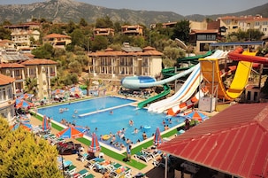 Un resort con piscina, toboganes acuáticos y vista a las zonas residenciales aledañas.