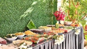 A buffet table with various food items and a decorative flower arrangement. - Gurol Hotel & Apart (Fethiye)