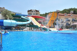 A swimming pool with multiple water slides and lounge chairs. - Gurol Hotel & Apart (Fethiye)