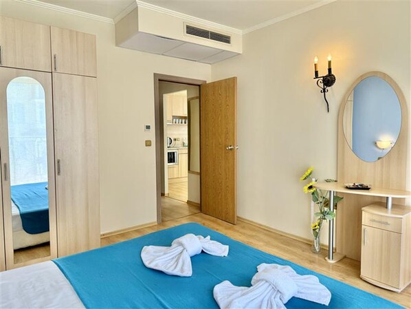 A hotel room with a bed, a bathroom, a kitchenette, and a view of the outside. - Menada Andalusia Apartments (Elenite)