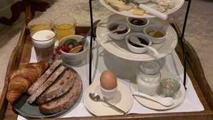 A breakfast tray with croissants, bread, eggs, and various spreads on a tray. - Hotel Hemelhuys (Hasselt)