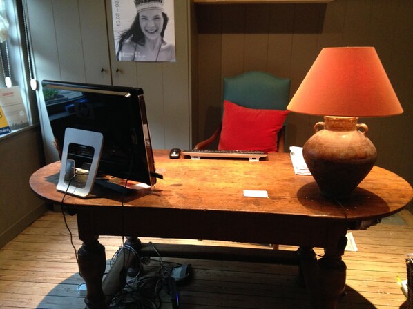 A wooden table with a laptop, a keyboard, a mouse, a vase, and a lamp. - Hotel Hemelhuys (Hasselt)