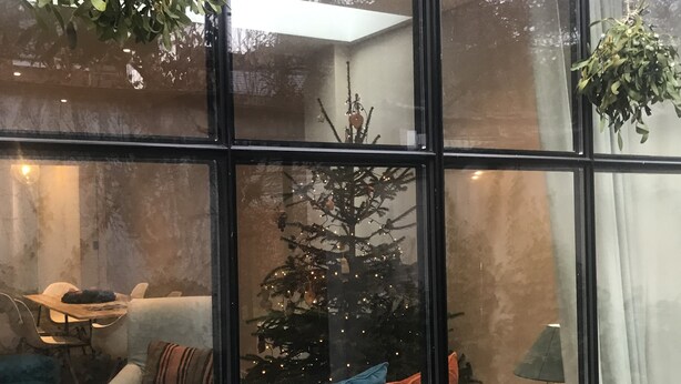 A cozy living room with a white sofa, a small table, and a Christmas tree. - Hotel Hemelhuys (Hasselt)
