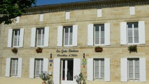 A two-story building with a sign reading "Les Gouttes Rivieres Chambres d'Hôtes." - Les Gués Rivières (Pujols)