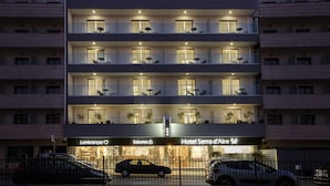 A multi-story hotel with balconies, a ground-level restaurant, and a visible car parking area. - Boutique Hotel Serra D’Aire (Ourem)