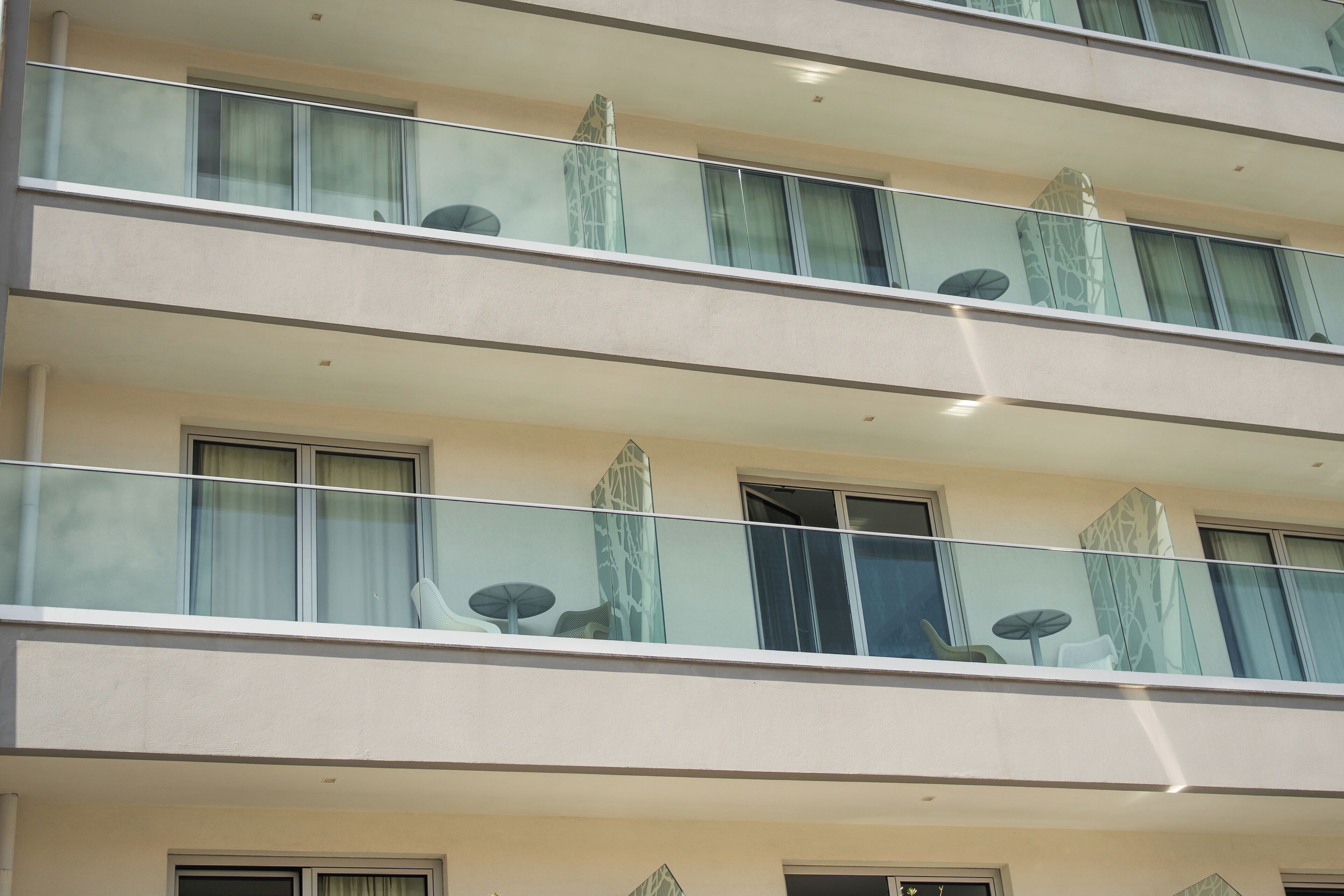 A multi-story hotel with balconies, large windows, and a modern architectural design.