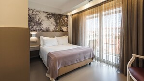 A hotel room with a large bed, a nightstand, a wall-mounted lamp, and a window with curtains. - Boutique Hotel Serra D’Aire (Ourem)