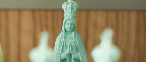 Una estatua de una figura vestida con túnica y corona, rodeada de figuras borrosas.