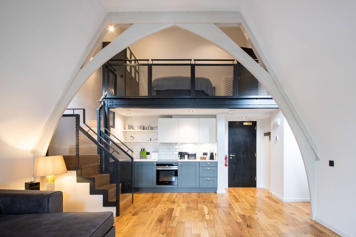 Un loft modern amb cuina, zona de dinar i espai de saló.