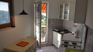Appartement, 2 chambres, terrasse (1A) | Cuisinette privée | Réfrigérateur, un four, surface de cuisson, vaisselle et ustensiles