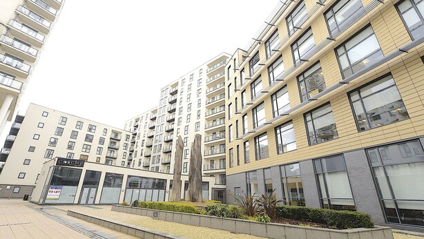 A modern apartment building with multiple floors, balconies, and a central courtyard with a sculpture. - SFA New Central Woking (Woking)
