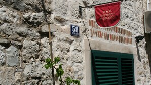 A stone building with a sign reading "58 Senjska" and a red banner for "Apartment Petricic." - Guest House Petricevic (Split)