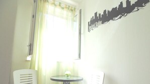 A room with two white chairs, a small round table, and a window with sheer curtains. - Guest House Petricevic (Split)