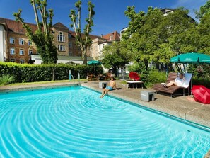 Piscine extérieure en saison, chaises longues
