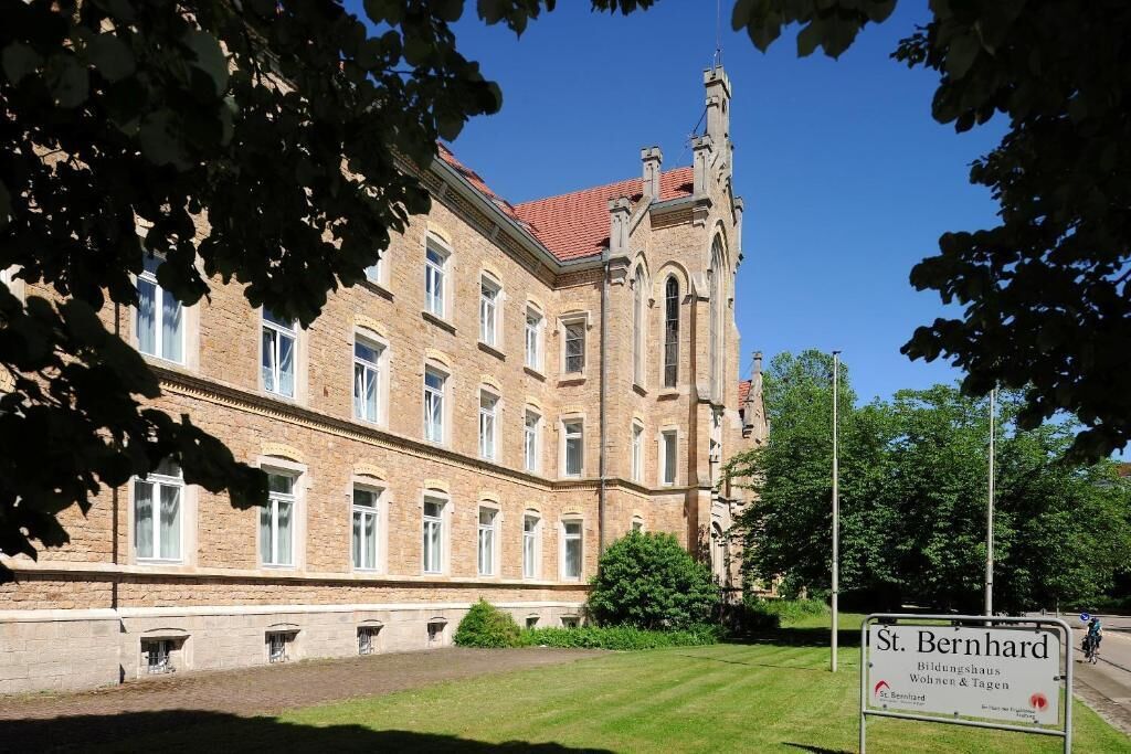 A large, historic building with a prominent tower and multiple windows.