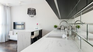 A modern kitchen with a marble countertop, stainless steel appliances, and a glass backsplash. - GA Luxury Apartments Wawrzynca 21 (Kraków)