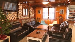 A cozy living room with leather sofas, a coffee table, and a Christmas tree. - Bellpark Hostel (Kriens)