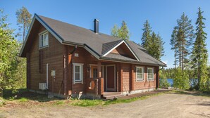 A log cabin with a gabled roof, a chimney, and a number '261' on the front.