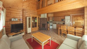 A spacious wooden cabin with a living area, kitchen, and dining space.
