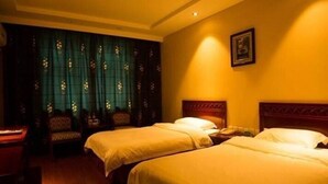 Een hotelkamer met twee bedden, een stoel en een bureau.